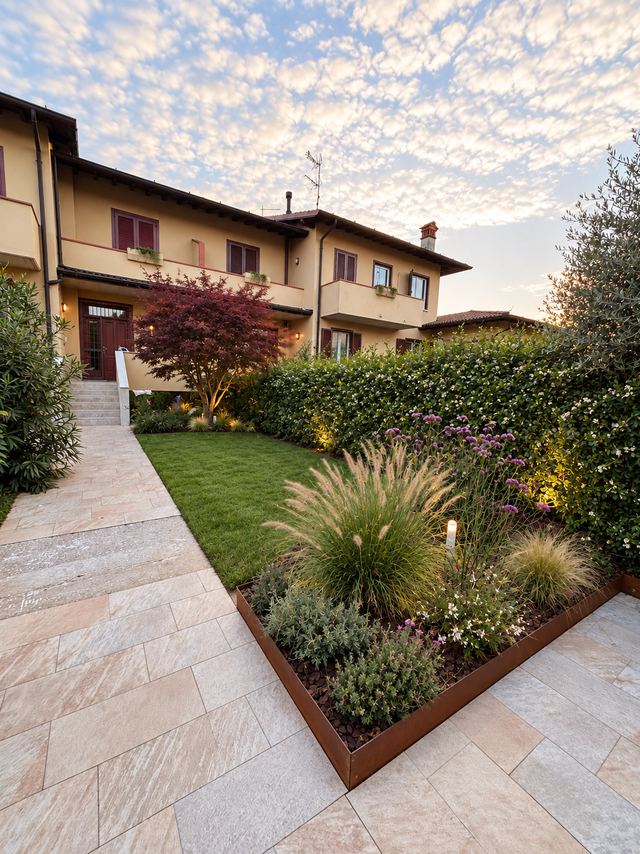 Progetto: aiuola con bordura in corten, graminacee, fioriture e luci